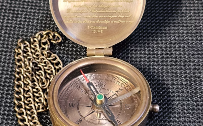 Open pocket compass with an engraved message inside the lid